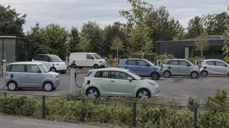 Voitures électriques d'occasion de formes variées en recharge sur un parking